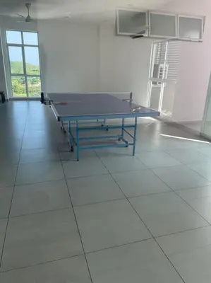a ping pong table in a room with a tiled floor at Georgetown ins cozy 2 bedroom in George Town