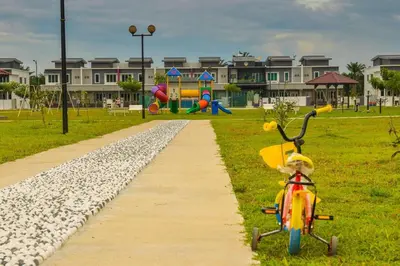 a childs bike parked next to a path in a park at 8Pax comfortable setia residen in Sitiawan