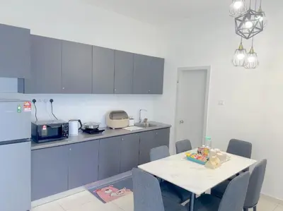 a kitchen with a table and a kitchen with a refrigerator at The Horizon Ipoh Blissful Homestay 2 in Ipoh