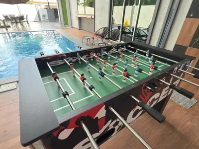 a ping pong table in front of a swimming pool at LYL Jaccuzi Private Pool House - 16PAX in Ipoh