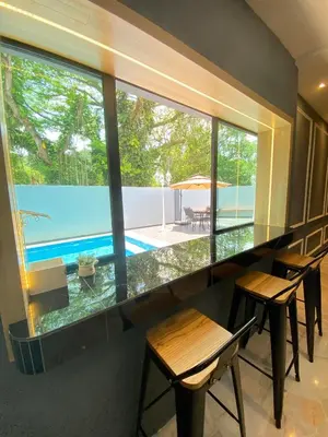 a room with a large window with chairs and a pool at LYL Jaccuzi Private Pool House - 16PAX in Ipoh