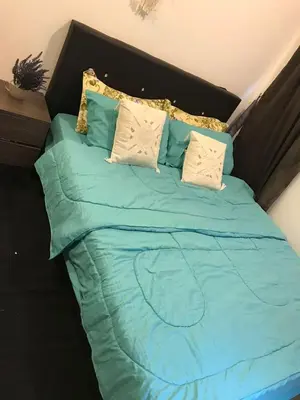 a bed with blue sheets and pillows on it at Palas Horizon in Kabus in Brinchang