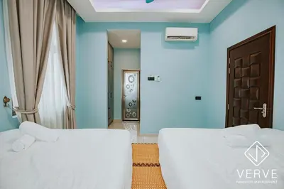 two beds in a room with blue walls at Ipoh Garden Luxury House By Verve (14pax) in Ipoh