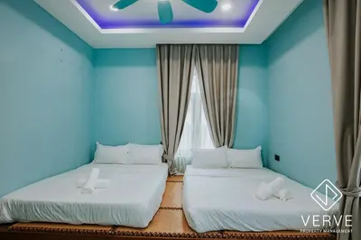 two beds in a room with blue walls and a ceiling at Ipoh Garden Luxury House By Verve (14pax) in Ipoh