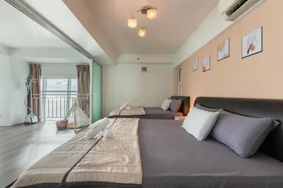 a bedroom with two beds and a couch at Maritime Seaview Comfy Suite Penang with TVbox,Pool,Freewifi,2-8pax in Jelutong