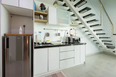 a kitchen with white cabinets and a staircase at Maritime Seaview Comfy Suite Penang with TVbox,Pool,Freewifi,2-8pax in Jelutong