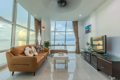 a living room with a couch and a tv at Maritime Seaview Comfy Suite Penang with TVbox,Pool,Freewifi,2-8pax in Jelutong
