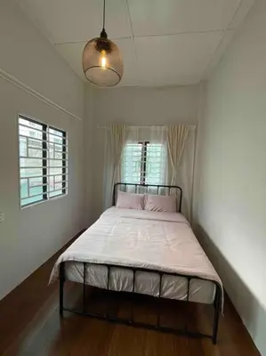 a bedroom with a large bed in a room at Modern Victorian Homestay in Jelutong