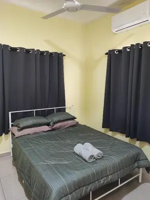 a bedroom with a bed with black curtains at Sal Homestay in Slim River