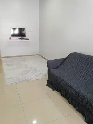 a bedroom with a bed and a tv on the wall at Sal Homestay in Slim River