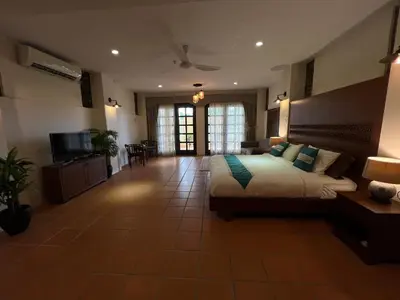 a large bedroom with a bed and a television at THE GARDEN SUITE in Balik Pulau