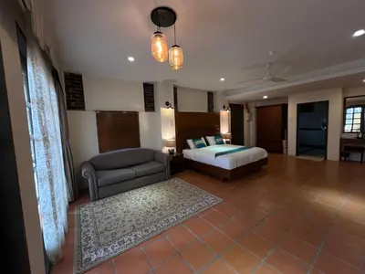a bedroom with a bed and a couch in a room at THE GARDEN SUITE in Balik Pulau