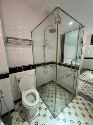 a bathroom with a toilet and a glass shower at THE GARDEN SUITE in Balik Pulau