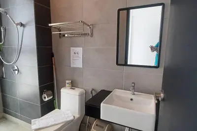a bathroom with a toilet and a sink and a mirror at Aesthetic Urban Suite With Infinite Pool & Gym in Jelutong