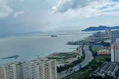 a view of a city with a bridge in the water at Aesthetic Urban Suite With Infinite Pool & Gym in Jelutong