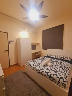 a bedroom with a bed with a ceiling fan at UniVilla- Ideal Family Home for 18pax in Gelugor