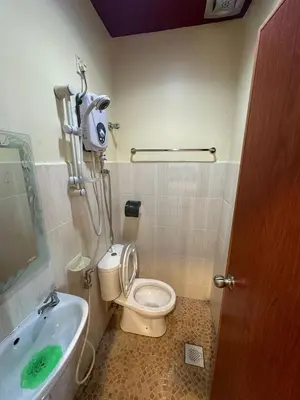 a bathroom with a toilet and a bath tub at Ezzy In Hotel in Seri Manjung