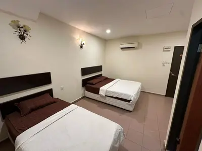 a hotel room with two beds in a room at Ezzy In Hotel in Seri Manjung