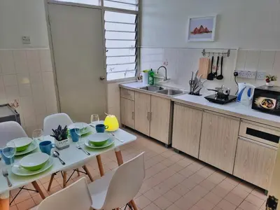 a kitchen with a table and chairs and a sink at Queensbay Mall, Up to 5 Pax, 2 Bedrooms, 1 Bathroom, 1 Car Park by Star Home in Bayan Lepas