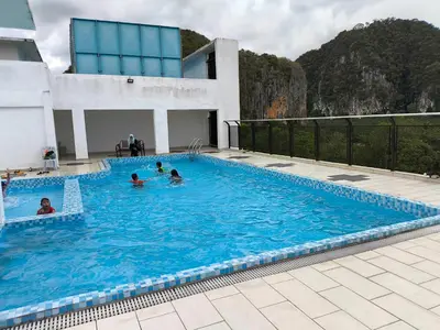 a group of people swimming in a swimming pool at ZH Studio Apartment Gua Musang With WIFI dan POOL in Gua Musang