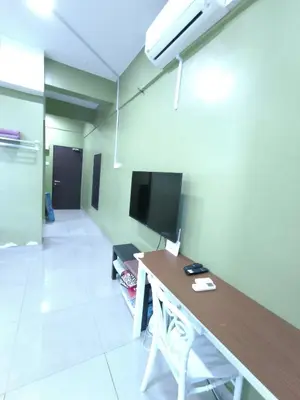 a room with a desk and a tv in a room at ZH Studio Apartment Gua Musang With WIFI dan POOL in Gua Musang