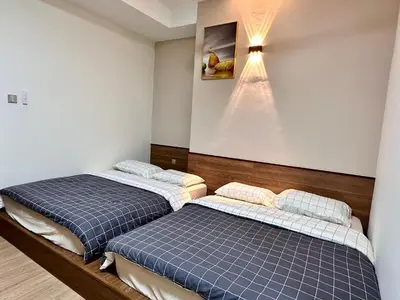 two beds in a room with a wall at Emerald Avenue Brinchang Muji style in Brinchang
