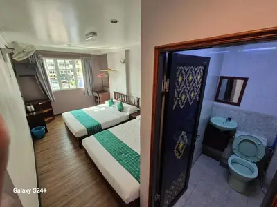 a small room with two beds and a toilet at Hotel Sentosa in Brinchang