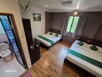 a hotel room with two beds and a toilet at Hotel Sentosa in Brinchang