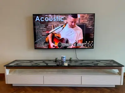 a tv screen with a man playing a guitar at 2Beds Seaview Waterfront Straits Quay w/Free Carpark And Bathub in Tanjong Tokong