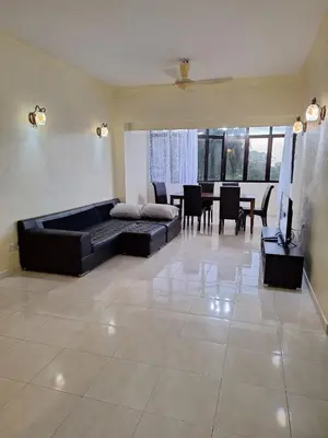 a living room with a couch and a dining room at Seaput Srisayang in Batu Ferringhi