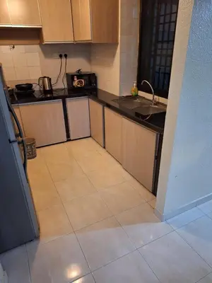 a kitchen with a tiled floor with a sink and a refrigerator at Seaput Srisayang in Batu Ferringhi