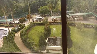 a view from a window of a park with a fountain at Seaput Srisayang in Batu Ferringhi