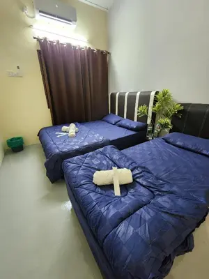 two beds in a room with blue sheets at Sun Shine Home by Ipoh Maju Stay in Ipoh