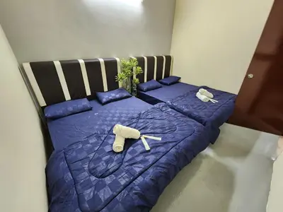 a bedroom with two beds with blue comforters at Sun Shine Home by Ipoh Maju Stay in Ipoh