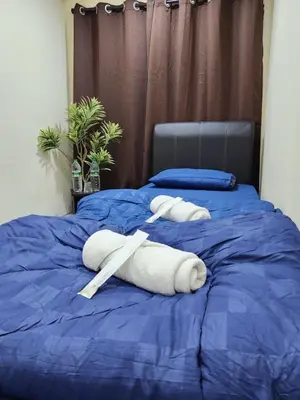 a towel animal is laying on a blue bed at Sun Shine Home by Ipoh Maju Stay in Ipoh
