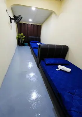 two beds in a room with blue sheets at Sun Shine Home by Ipoh Maju Stay in Ipoh