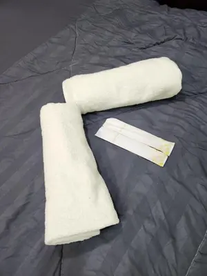 a stack of white towels on a bed at Sun Shine Home by Ipoh Maju Stay in Ipoh