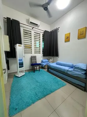 a living room with two beds and a mirror at Nurasyura Puncak Guesthouse in Seri Iskandar