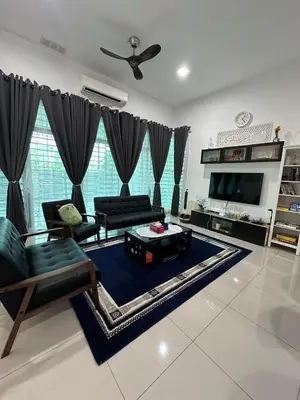 a living room with a couch and a tv at Nurasyura Puncak Guesthouse in Seri Iskandar