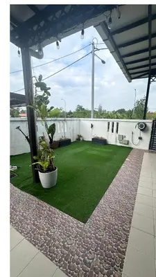 a patio with grass and plants on a building at Nurasyura Puncak Guesthouse in Seri Iskandar