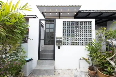 a white house with a black door and some plants at Casa for 2 - Private Studio Ipoh in Ipoh