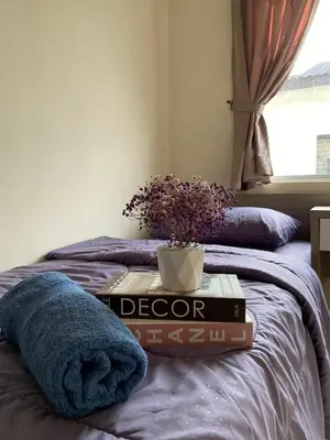 a pile of books sitting on top of a bed at Homestay Khan'Da Teluk Intan in Teluk Intan