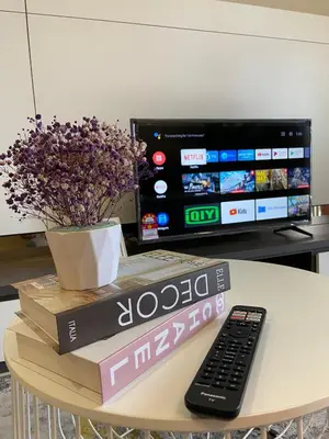 a remote control sitting on top of a table with a tv at Homestay Khan'Da Teluk Intan in Teluk Intan