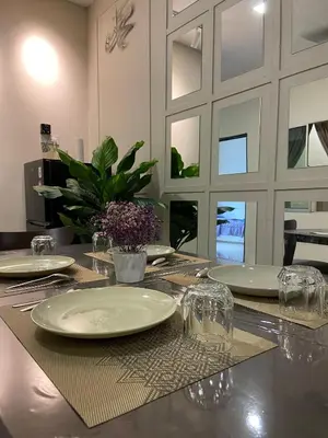 a dining room table with plates and glasses on it at Homestay Khan'Da Teluk Intan in Teluk Intan
