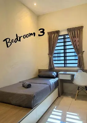 a bedroom with a bed with a desk and a window at Homestay Khan'Da Teluk Intan in Teluk Intan