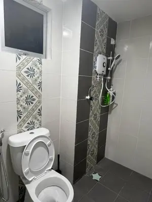a bathroom with a toilet with a tv on the wall at Ipoh Town Anderson Haru Suite 7 paxs 2R2B in Ipoh