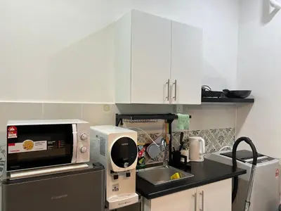a kitchen with white cabinets and a microwave at Ipoh Town Anderson Hana Suite 7 paxs 2R2B in Ipoh