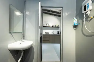 a bathroom with a sink and a shower with a mirror at Mono Ipoh - Bercham, 2 parking, sleep 10, Lost World Tambun in Ipoh