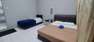 a small bedroom with two beds and a couch at Sobey Laris Roomstay GUA MUSANG in Gua Musang