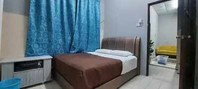 a bedroom with a bed and a blue curtain at Sobey Laris Roomstay GUA MUSANG in Gua Musang
